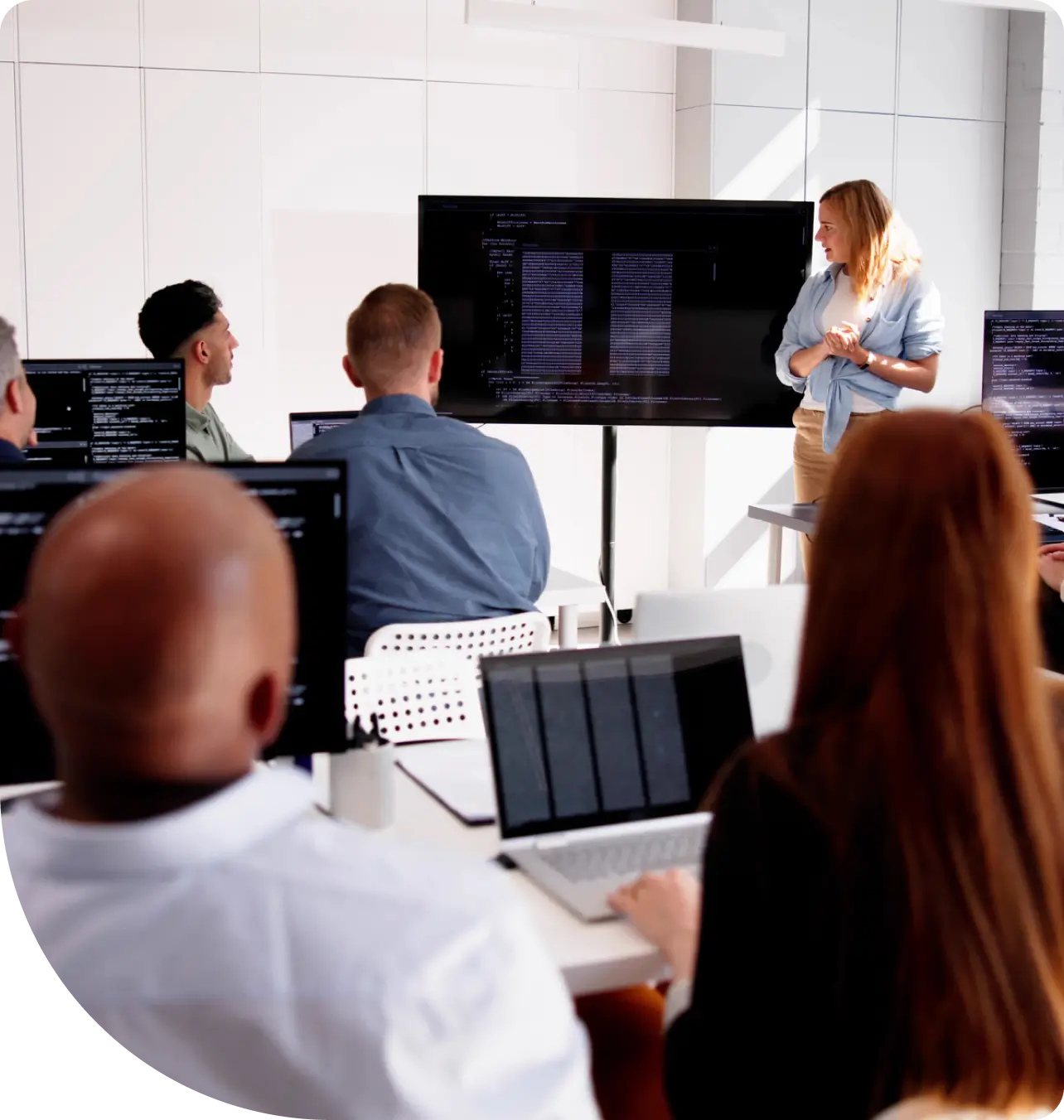 Classroom presentation with people and laptops.